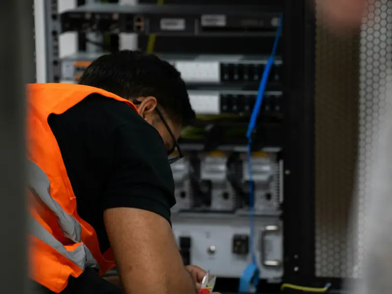 A technician wiring equipment at an open rack